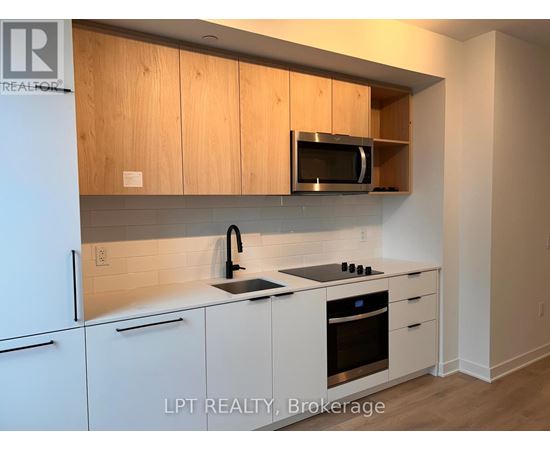 A kitchen with white cabinets and a microwave above the stove.
