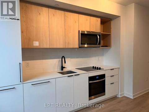 A kitchen with white cabinets and a microwave above the stove.
