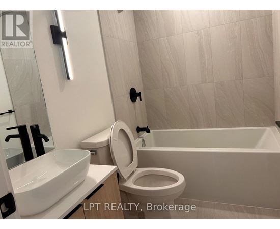 A white toilet with a white sink and a white bathtub in a bathroom.