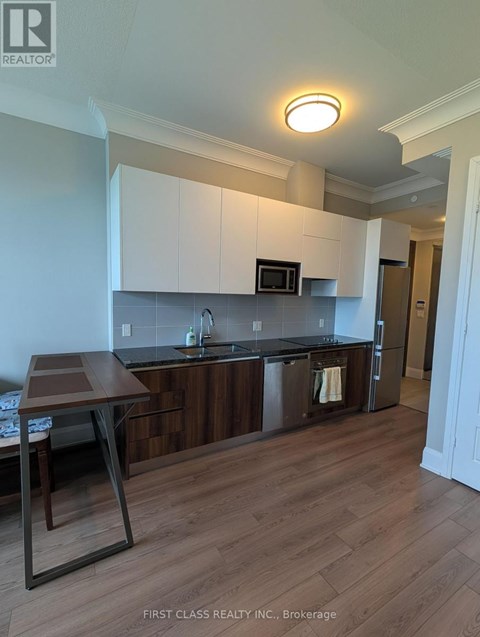A kitchen with dark wood cabinets and a black counter top.