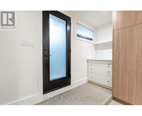 A black door with a glass window is in a room with white walls.