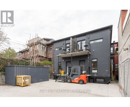 A forklift is parked in front of a grey building.