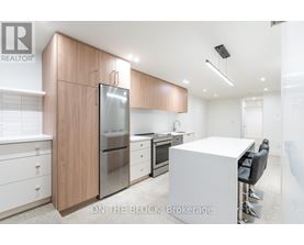 A modern kitchen with a refrigerator, stove, and dining table.