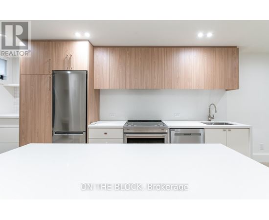 A modern kitchen with wooden cabinets and stainless steel appliances.
