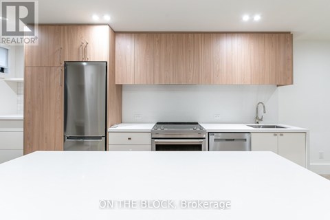 A modern kitchen with wooden cabinets and stainless steel appliances.
