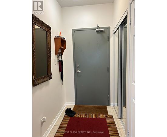 A hallway with a rug and a mirror on the wall.