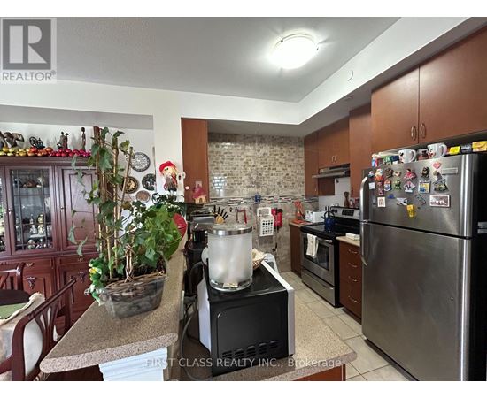 A kitchen with a refrigerator covered in magnets and a pot on the stove.