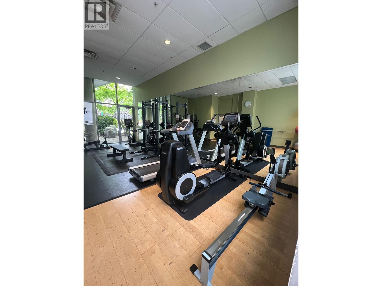 A gym with a variety of equipment including treadmills, weights, and exercise machines.