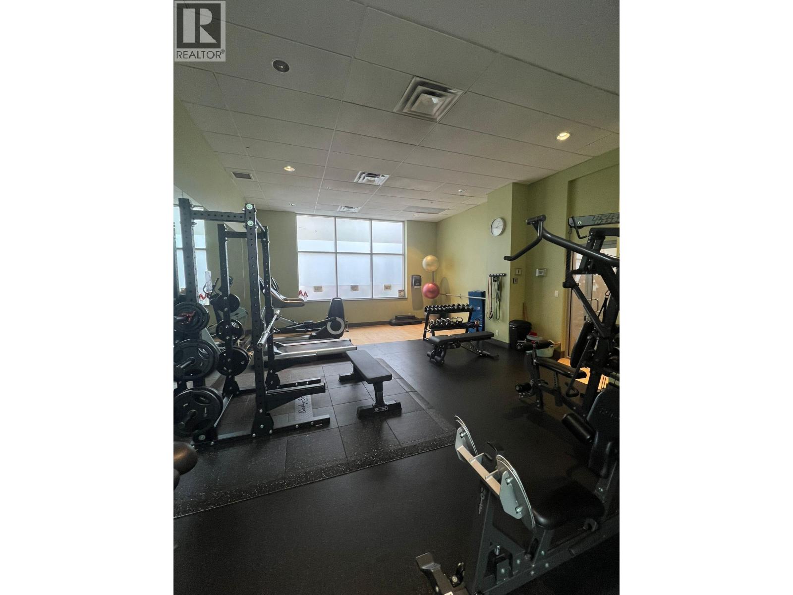 A gym with a variety of equipment including a treadmill, weights, and a bench press.