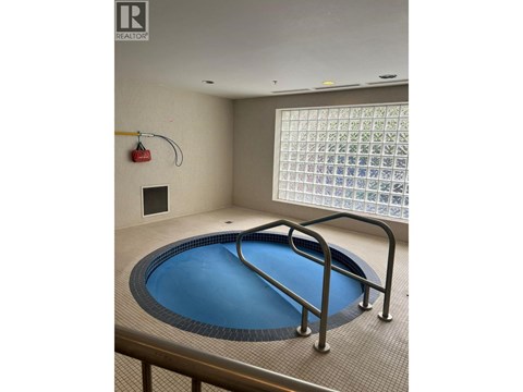 A small indoor pool with a metal railing around it.