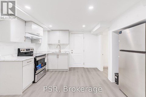 A kitchen with white cabinets and appliances is on the market.