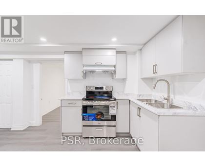A modern kitchen with a stainless steel oven and white cabinets.