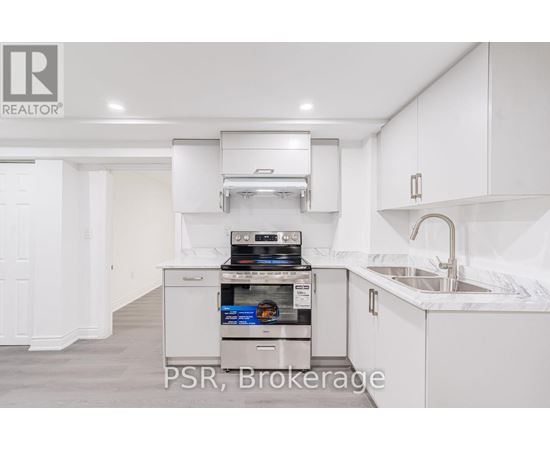 A modern kitchen with a stainless steel oven and white cabinets.
