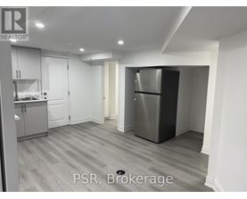 A kitchen with a refrigerator and cabinets.