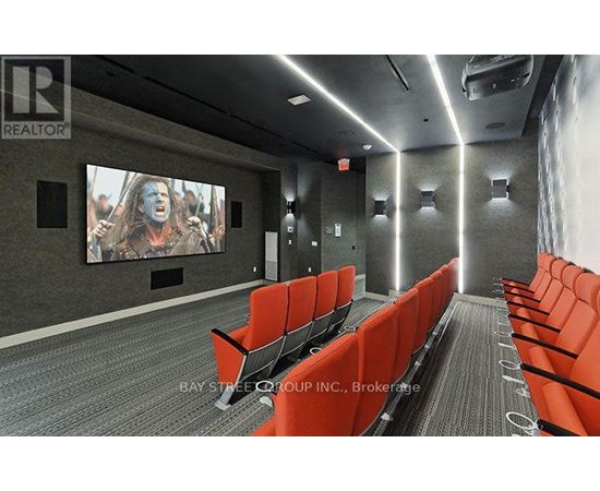 A movie theater with red seats and a large screen.