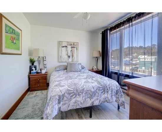 A bedroom with a large bed and a painting on the wall.