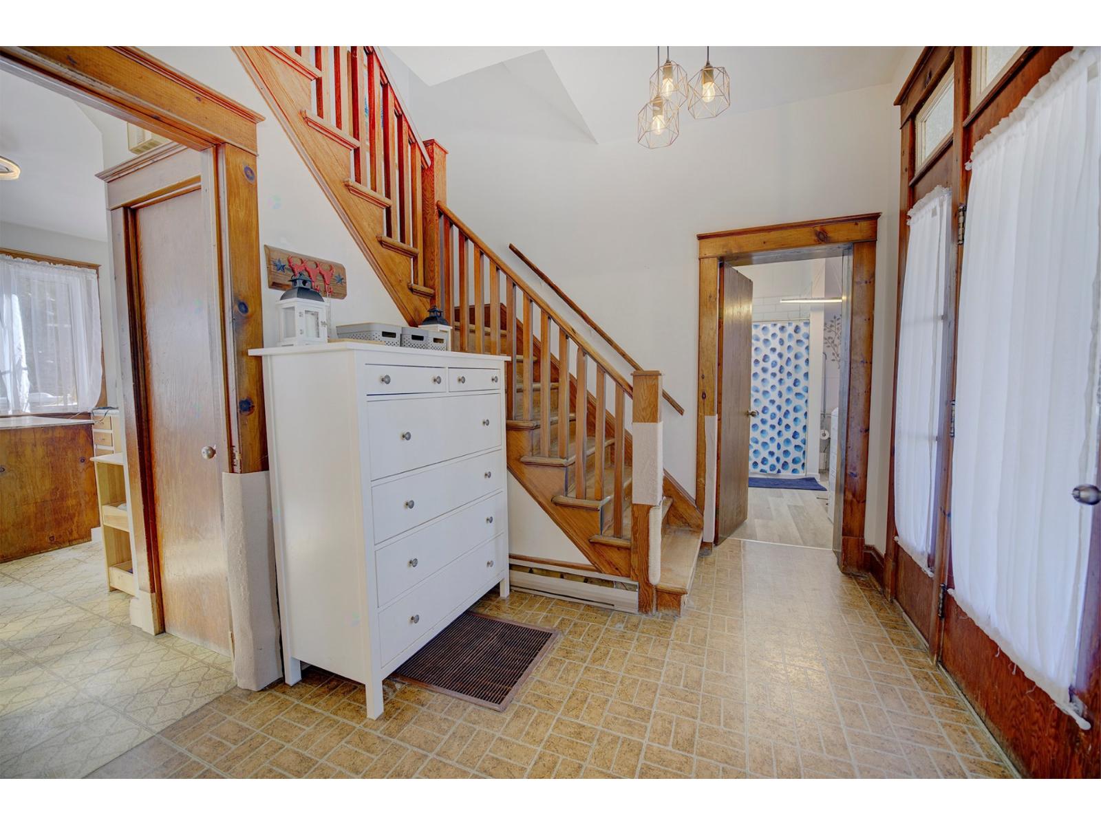 A white kitchen with a wooden staircase.