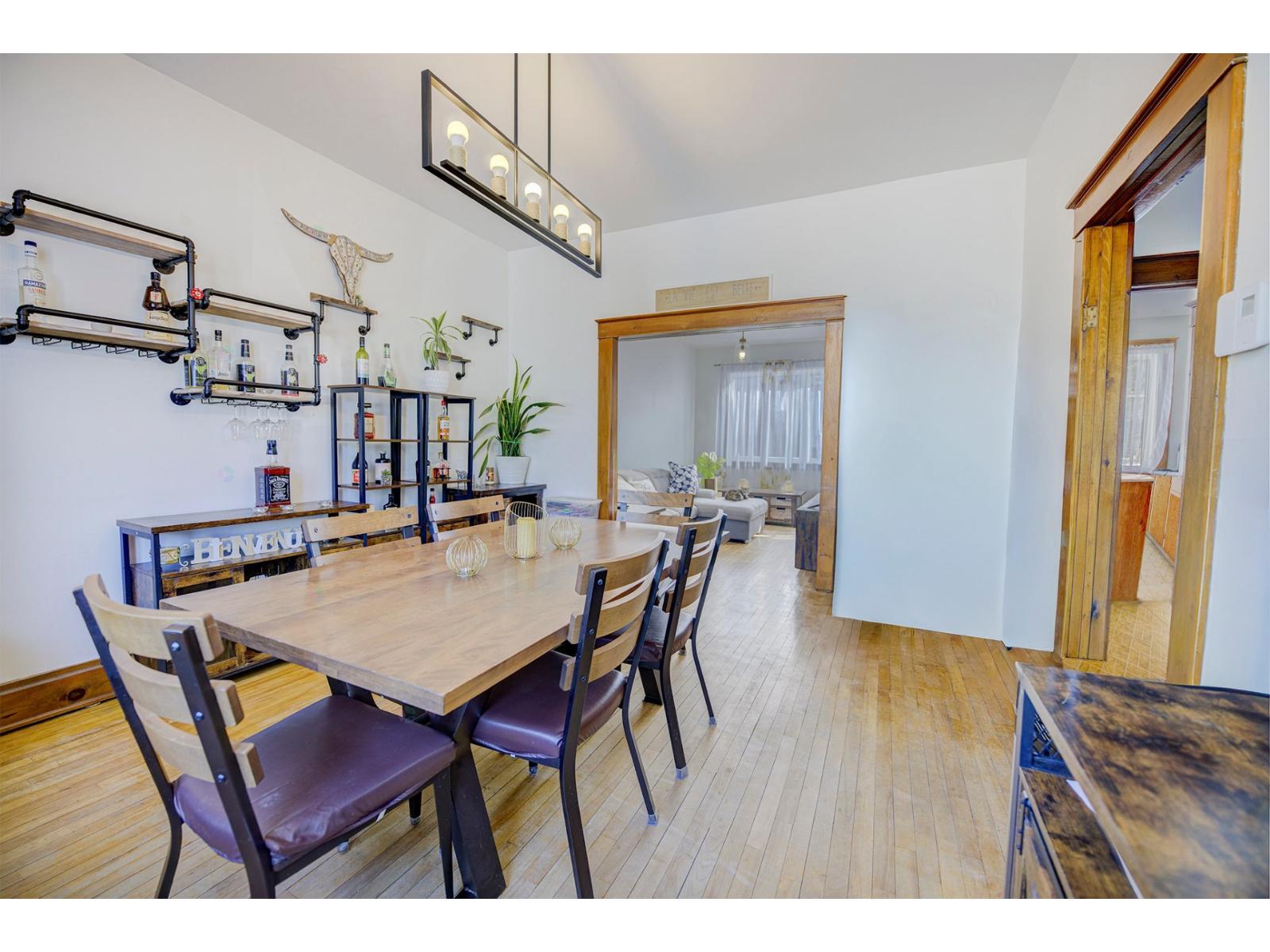 A dining room with a wooden table and chairs.