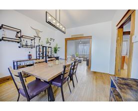 A dining room with a wooden table and chairs.