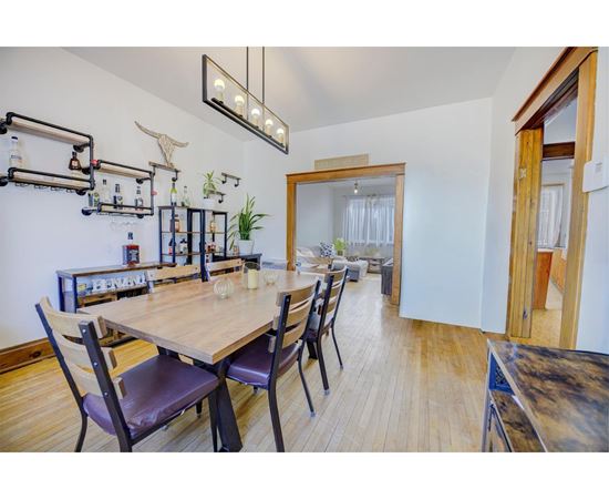 A dining room with a wooden table and chairs.