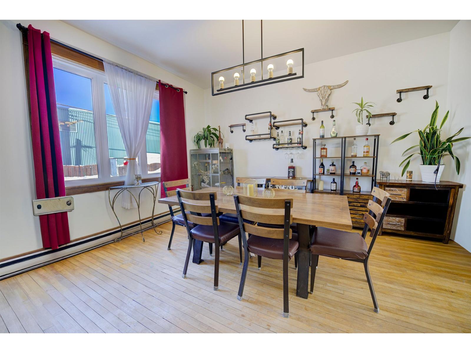 A dining room with a wooden table and chairs.