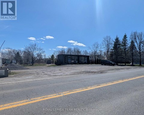 A building with the sign "ROYAL LEPAGE TEAM REALTY Brokerage" is visible in the foreground of a street.