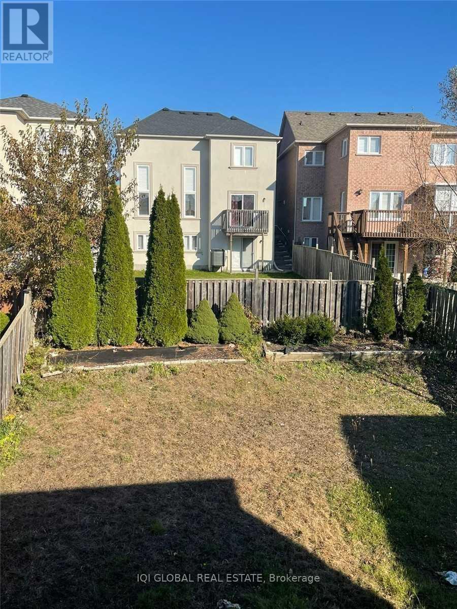 A sunny day in a yard with a fence and a few trees.