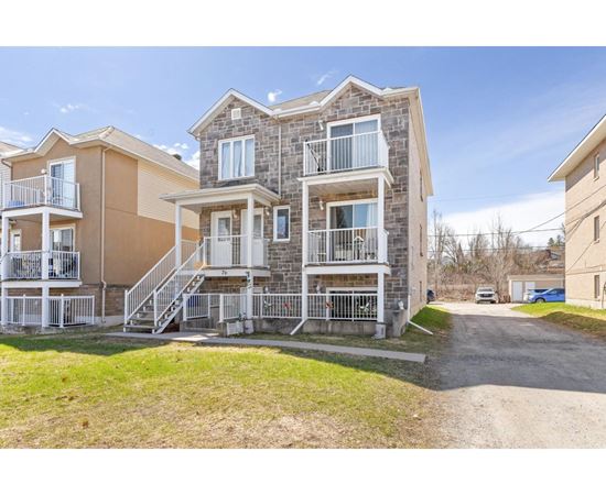 A large two-story apartment building with a balcony on the second floor.
