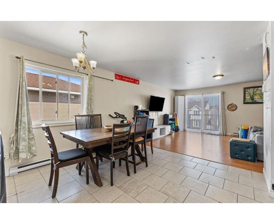 A dining room with a wooden table and chairs.