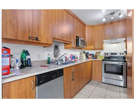 A kitchen with wooden cabinets and a stainless steel oven.