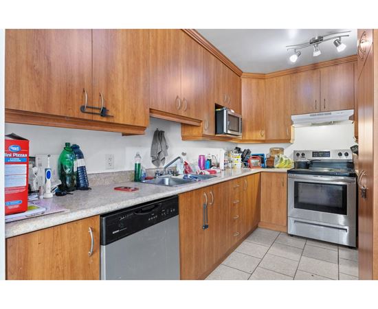 A kitchen with wooden cabinets and a stainless steel oven.
