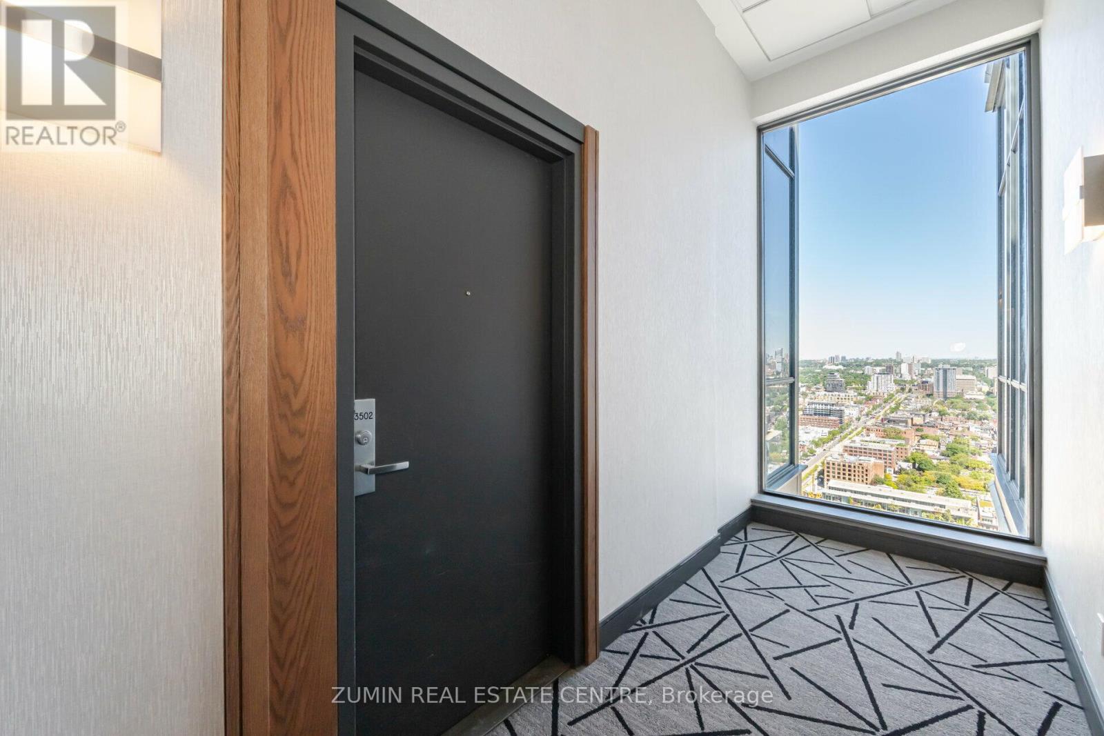 A room with a view of the city through a large window.