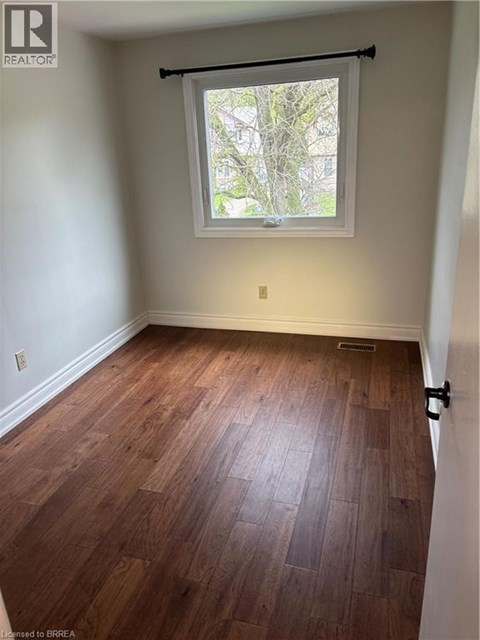 A room with wooden flooring and a window.