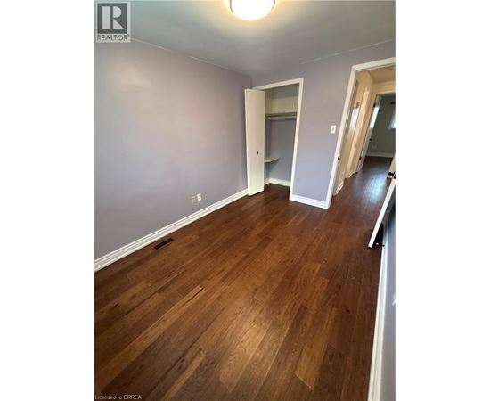 A room with wooden flooring and a white door.