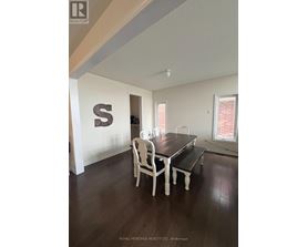 A dining room with a table and chairs.
