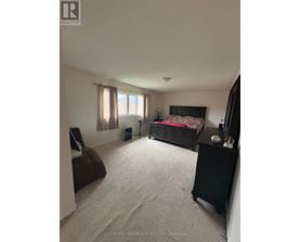 A bedroom with a bed, nightstand, and chair.