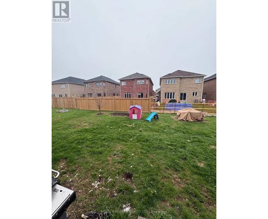 A backyard with a fence and a swimming pool.