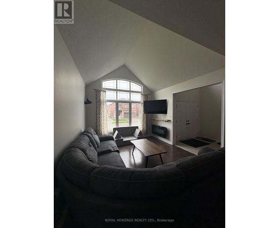 A living room with a grey couch and a television.