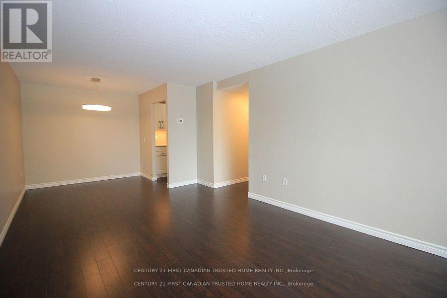 A spacious room with wooden floors and white walls.