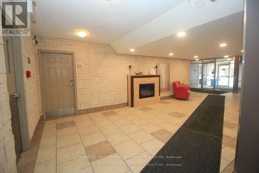 A living room with a fireplace and a red chair.