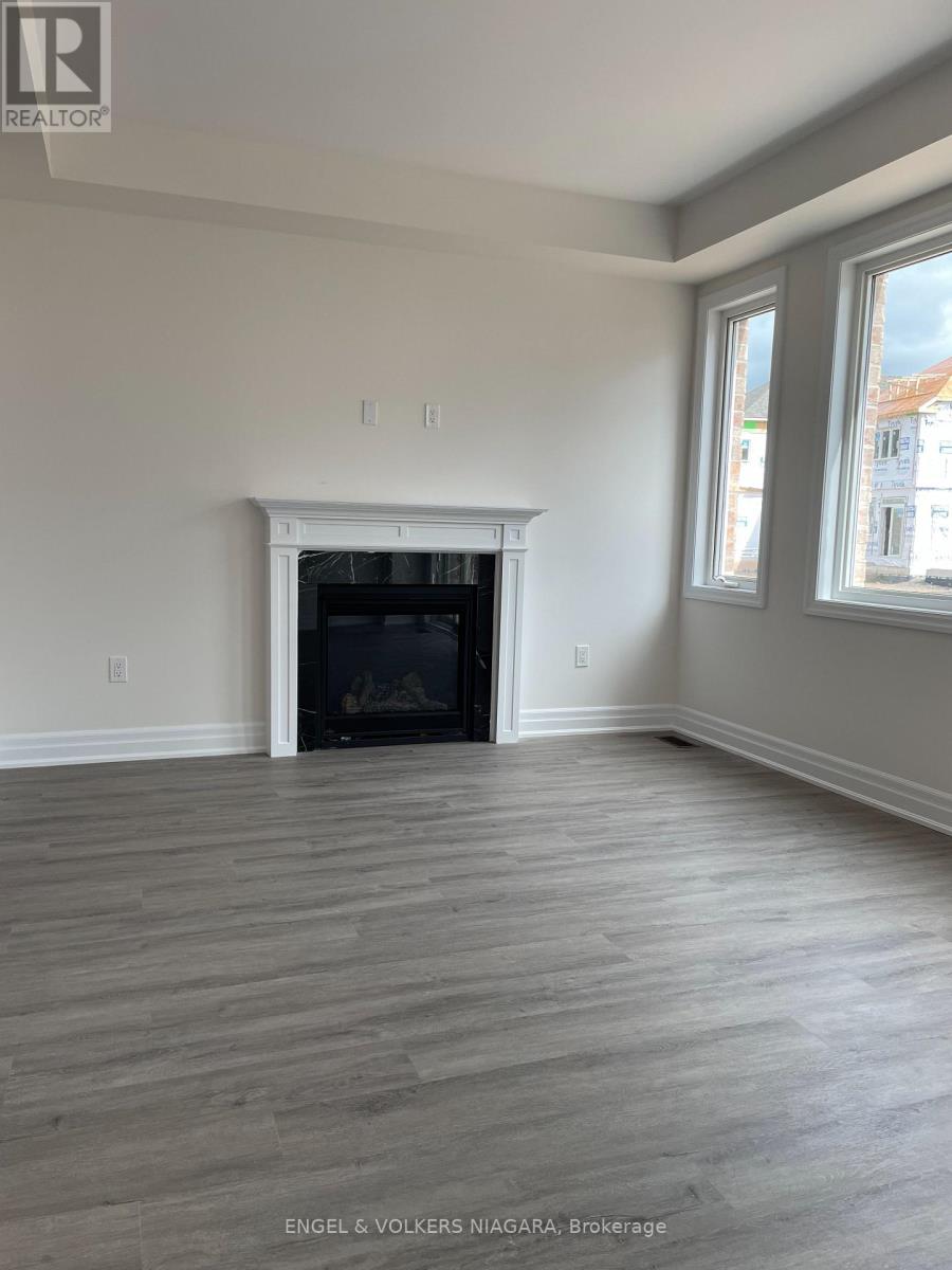 A living room with a fireplace and wood flooring.