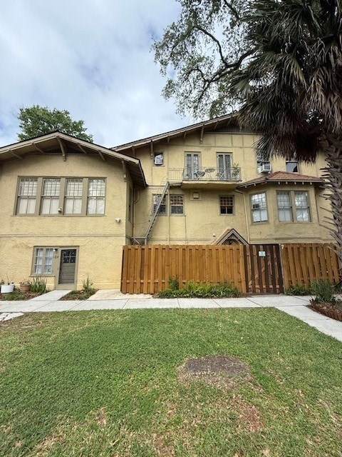 A two-story house with a wooden fence in front.