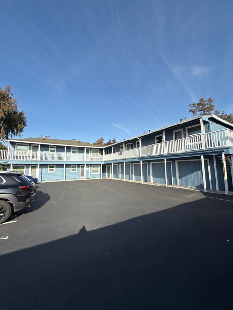 A blue building with a car parked in front.