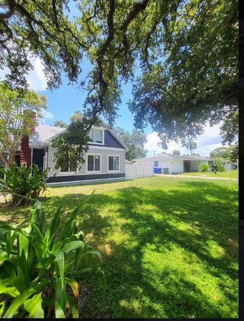 A house with a white fence and a green lawn.