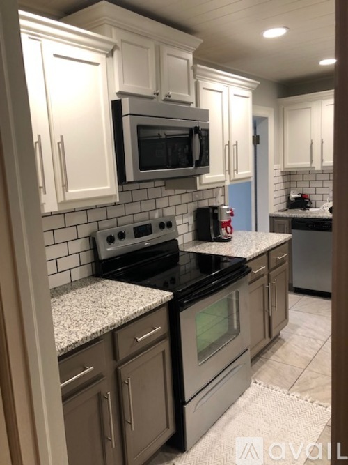 A kitchen with a black stove top oven and a black microwave above it.