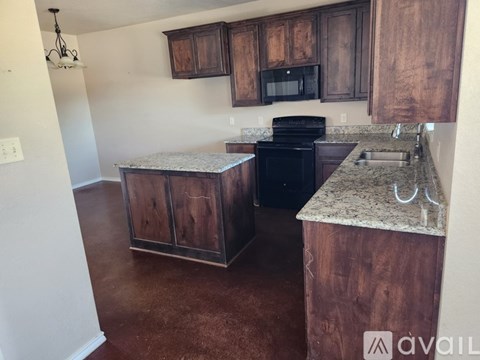 A kitchen with brown cabinets and a black stove top oven.