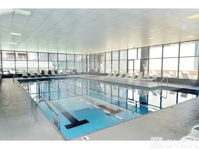 A large indoor swimming pool with a diving board.
