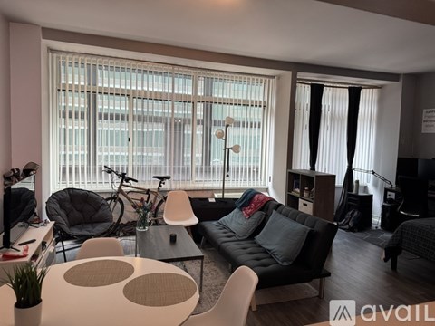 A living room with a black couch and a bicycle.