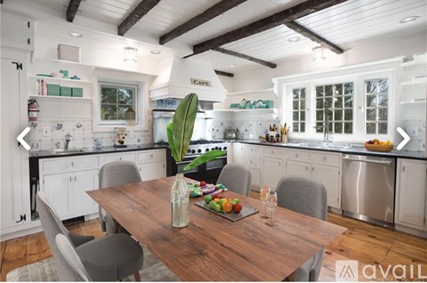 A modern kitchen with a wooden table set for two.