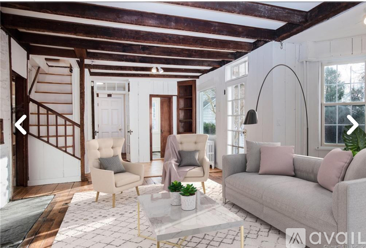 A living room with a couch, two chairs, and a coffee table.